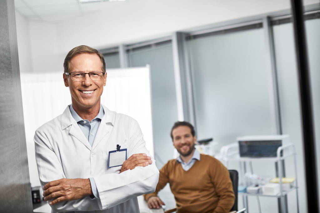 Smiling doctor is standing in his office - Photo, Image