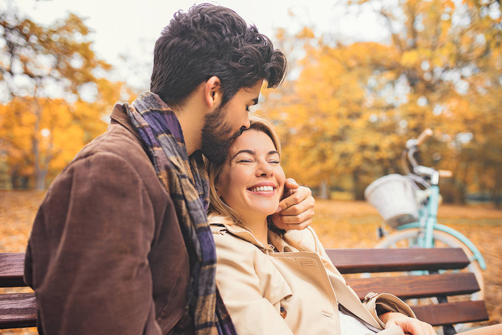 Lächelndes junges Paar genießt Herbst im Park. - Foto, Bild