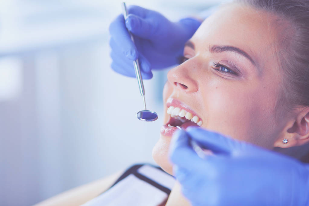 Młoda pacjentka z otwartymi ustami badająca badanie stomatologiczne w gabinecie stomatologicznym. - Zdjęcie, obraz