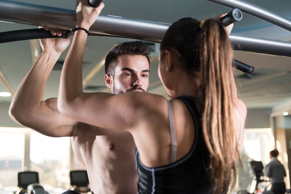 Young Couple Doing Heavy Weight Exercise For Pull Ups or Chin-ups - Photo, Image