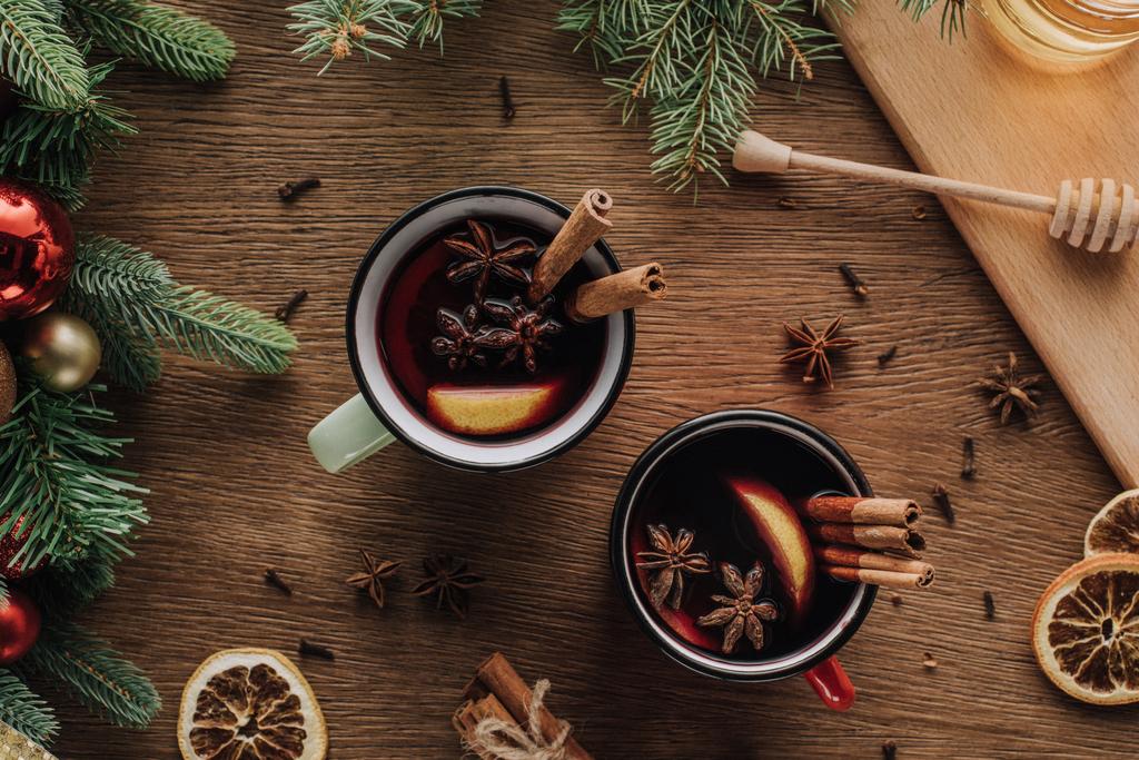 vue du dessus des tasses de vin chaud avec œillet et bâtonnets de cannelle sur table en bois, concept de Noël
 - Photo, image