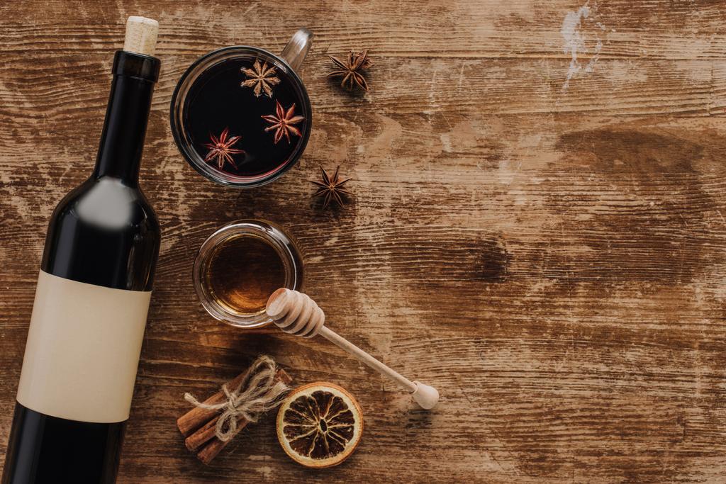 vista superior del vino caliente, la miel y la botella de vino en la mesa de madera
 - Foto, imagen