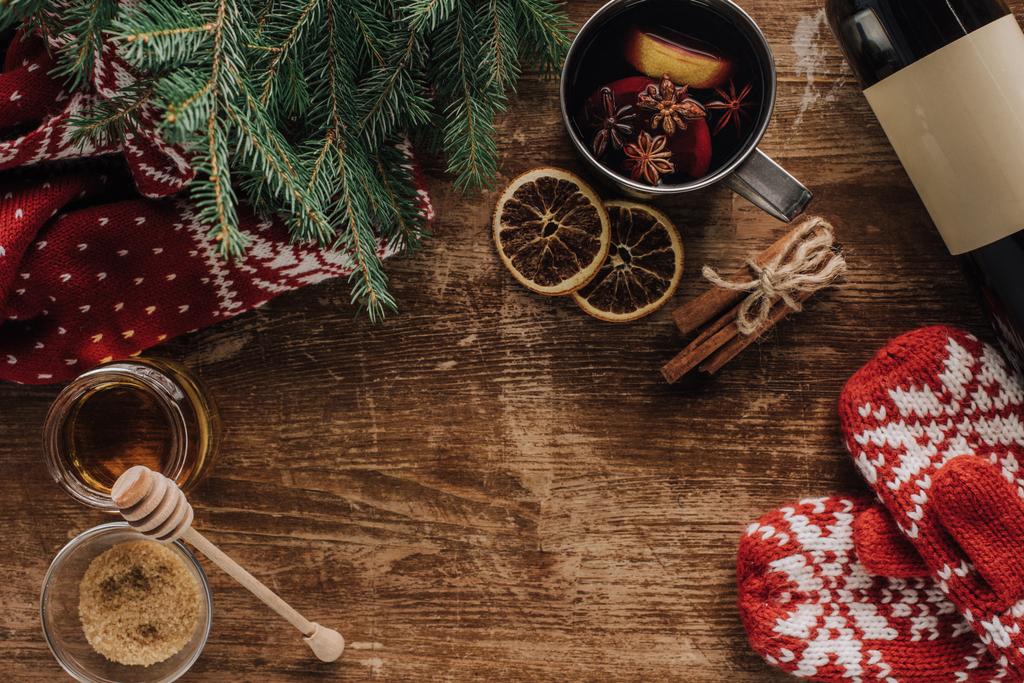 top view of mulled wine in cup and mittens on wooden tabletop, christmas concept - Photo, Image