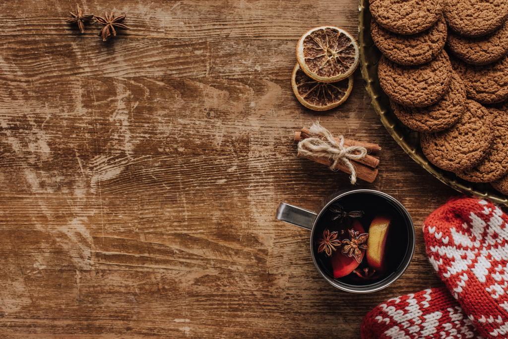 Widok z góry z grzanym winem w Pucharze, rękawiczki i ciasteczka na drewnianym stole, Boże Narodzenie koncepcji - Zdjęcie, obraz