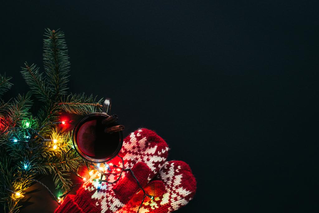 vista superior de la taza de vino caliente, guirnalda y mitones aislados en negro, concepto de Navidad
 - Foto, Imagen