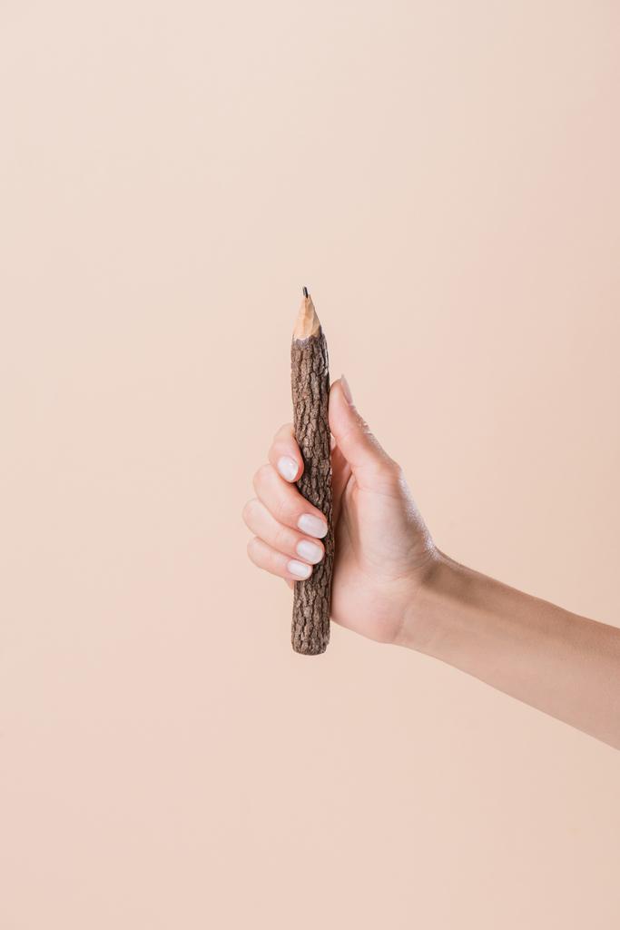 περικοπεί shot γυναίκας κρατάει μολύβι έκανε ραβδί που απομονώνονται σε μπεζ - Φωτογραφία, εικόνα