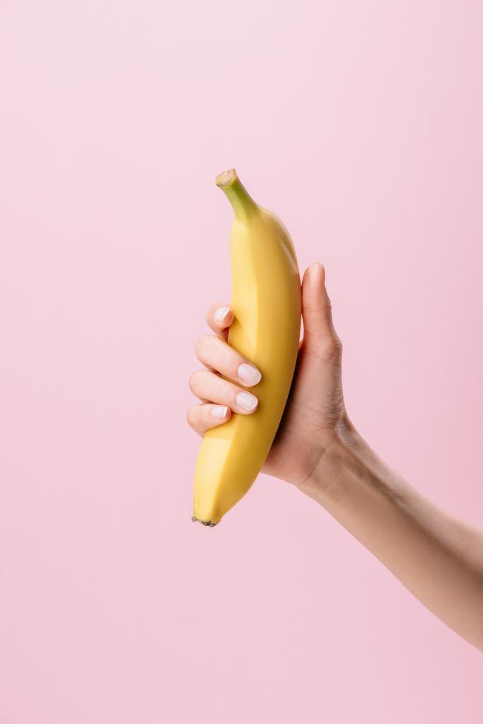 foto recortada de la mujer sosteniendo plátano aislado en rosa
 - Foto, Imagen