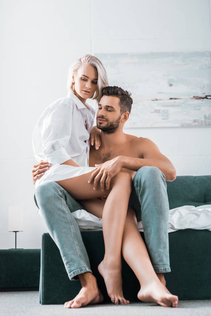 attractive young couple in sitting on bed together - Photo, Image