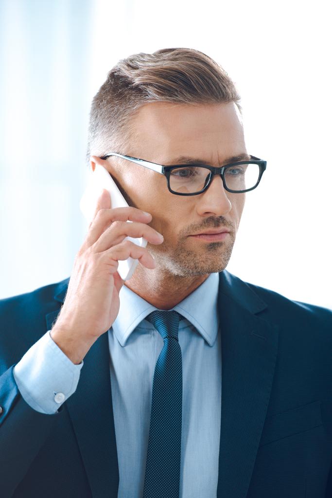bel homme d'affaires en lunettes parler par smartphone et détourner les yeux
  - Photo, image