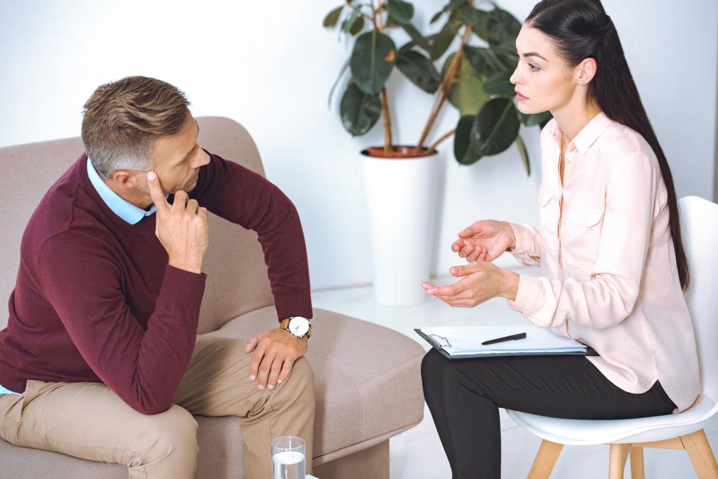 kobiece psycholog rozmawia podczas sesji terapii pacjenta na kanapie - Zdjęcie, obraz