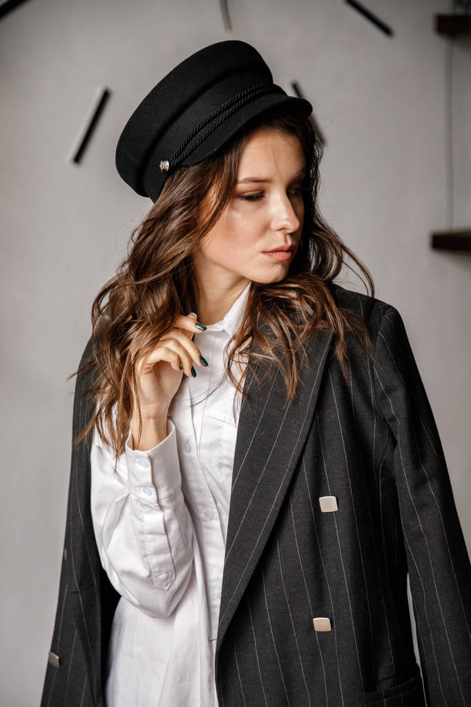 Modeporträt der Schönheit brünettes Modell trägt schwarze Jacke, weißes Hemd und rosa Hose. junge schöne Frau posiert in Luxus-Appartements - Foto, Bild