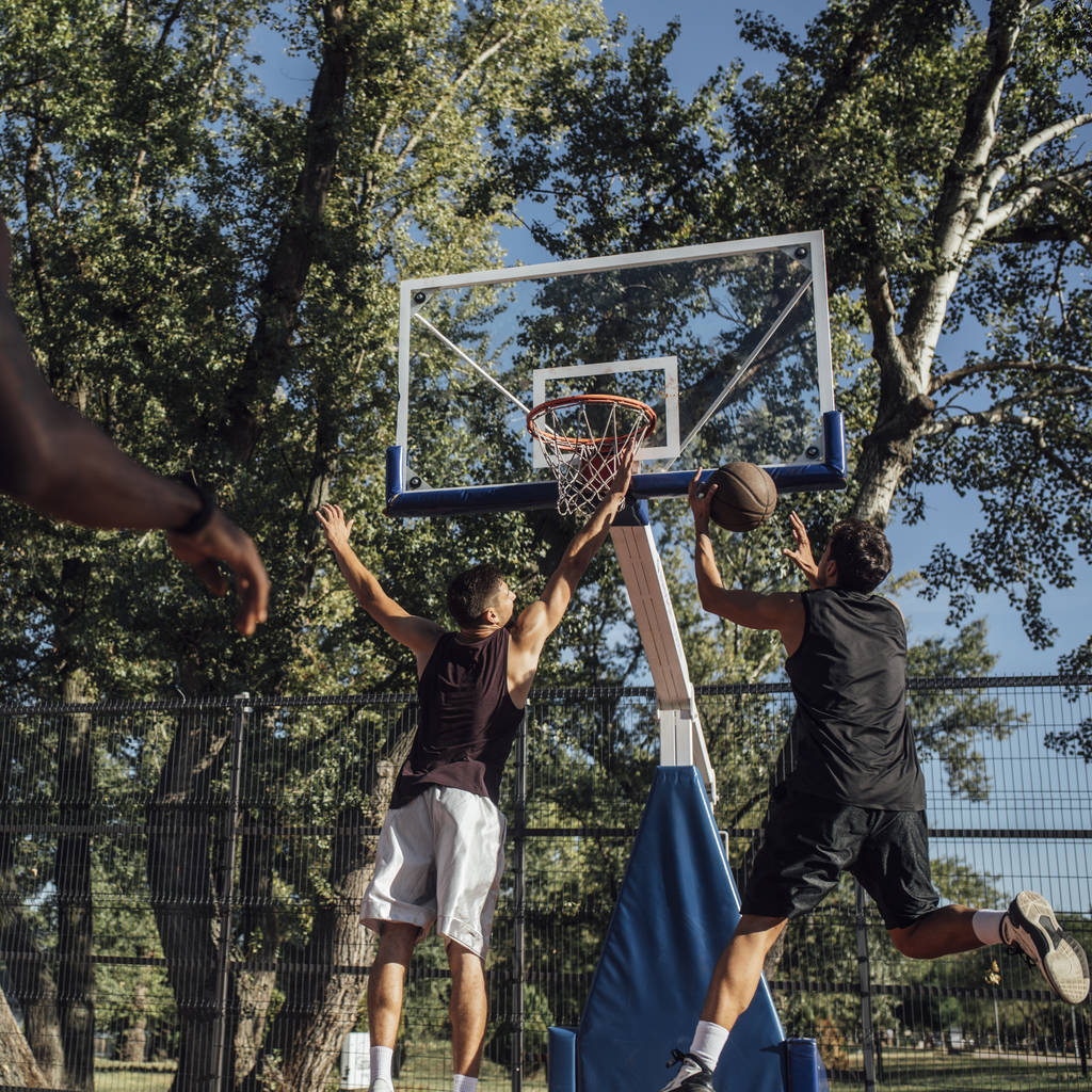 Grupo de jovens desportistas jogando basquete na quadra ao ar livre
. - Foto, Imagem