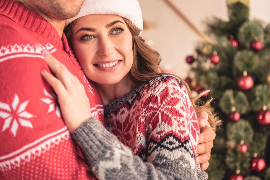 rajattu kuva aviomies ja hymyilevä vaimo halaus lähellä joulukuusi kotona
 - Valokuva, kuva