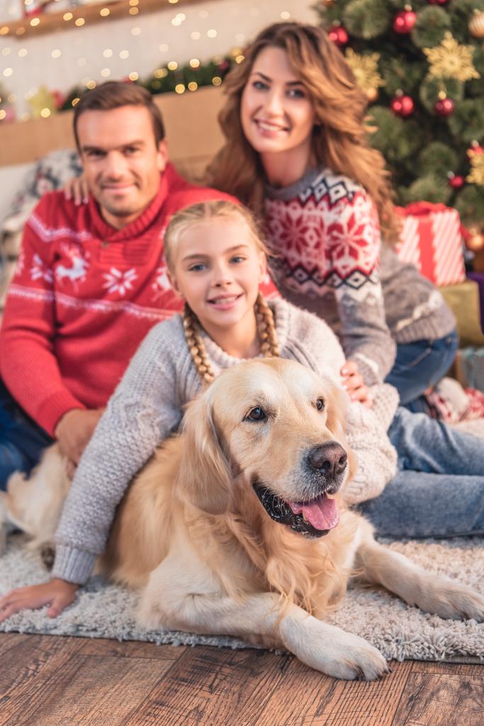souriant famille et fille avec golden retriever chien assis près de l'arbre de Noël avec des cadeaux
 - Photo, image