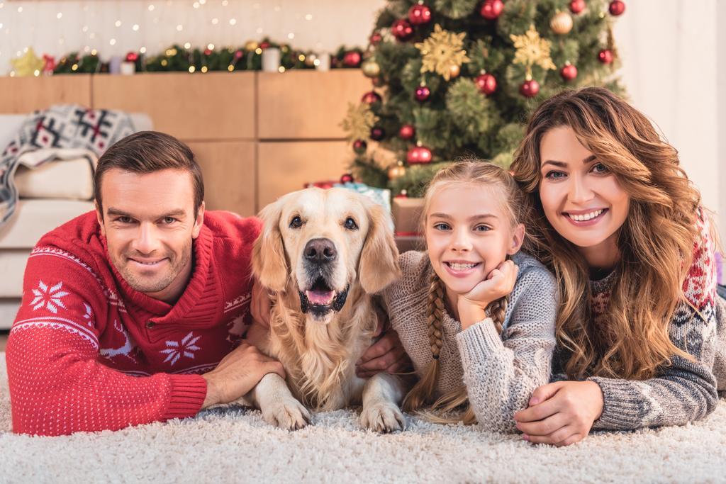famille avec golden retriever chien couché près de l'arbre de Noël ensemble
 - Photo, image