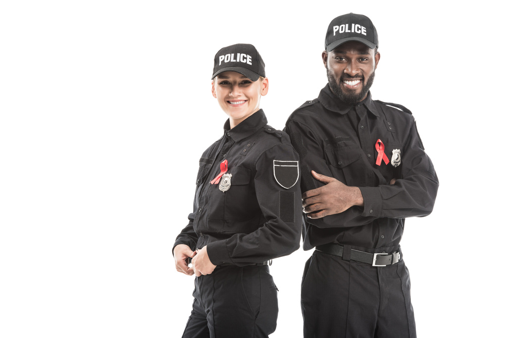successful police officers with aids awareness red ribbons looking at camera isolated on white - 写真・画像