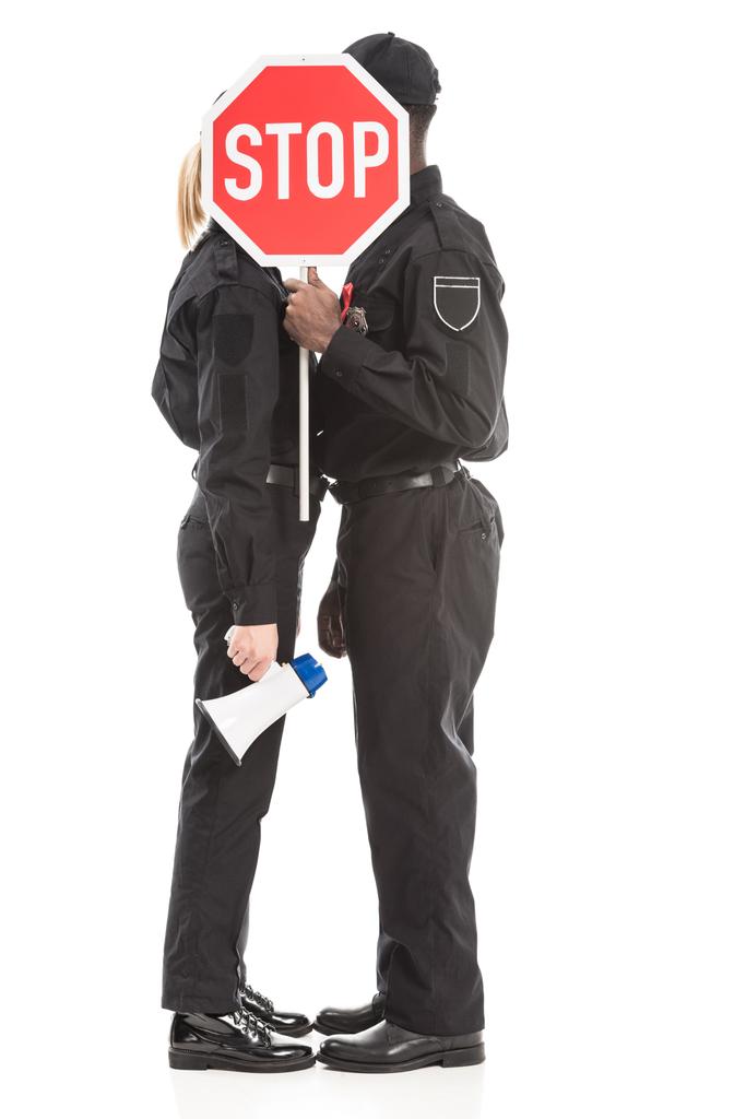 oficiales de policía escondidos detrás de señal de stop road y besos aislados en blanco
 - Foto, imagen
