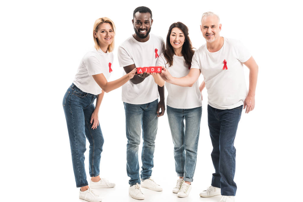 grupo de personas multiétnicas en camisetas blancas en blanco con cintas rojas de sensibilización de sida que sostienen bloques con letras de SIDA aisladas en blanco
 - Foto, imagen