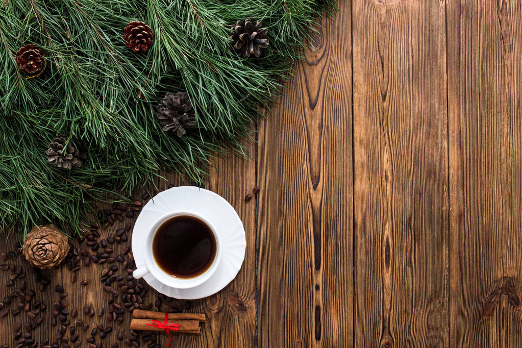 fir branches, cup of coffee and cinnamon on wooden new year background, copy-space - Photo, Image