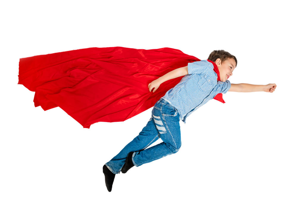 Chłopiec latający w czerwony płaszcz superbohatera na białym tle. Na białym tle - Zdjęcie, obraz