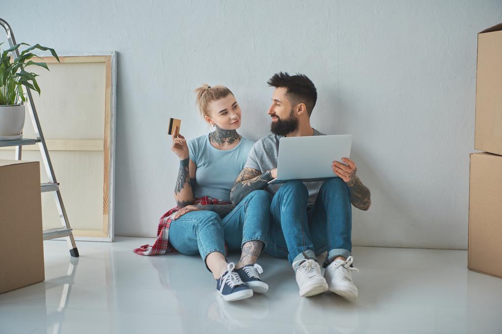 dizüstü bilgisayar ve kredi kartı alışveriş online yeni evde ile çift gülümseyen - Fotoğraf, Görsel