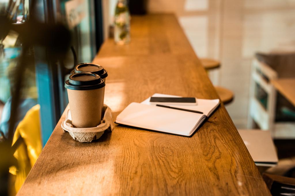 two disposable coffee cups, open notebook with pen on cafe counter - Photo, Image