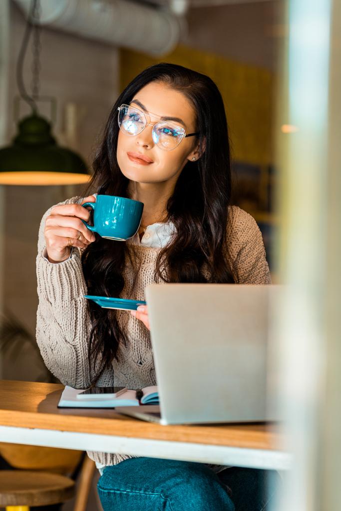 привлекательная женщина на кофе-брейке в кафе с ноутбуком
 - Фото, изображение