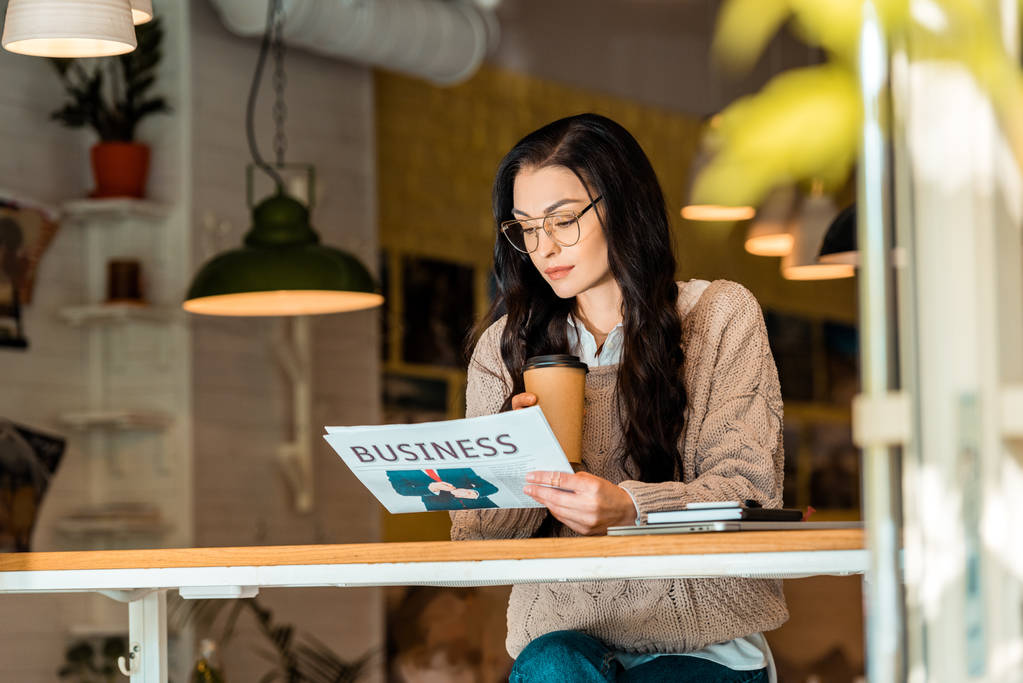 mulher atraente com café para ir ler jornal de negócios no café
   - Foto, Imagem