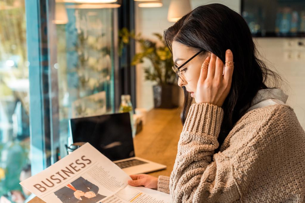 魅力的な女性のビジネス ノート パソコンをカフェで新聞を読む - 写真・画像