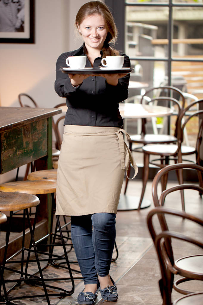 Портрет официантки, держащей поднос с кофейными чашками в кафе
 - Фото, изображение