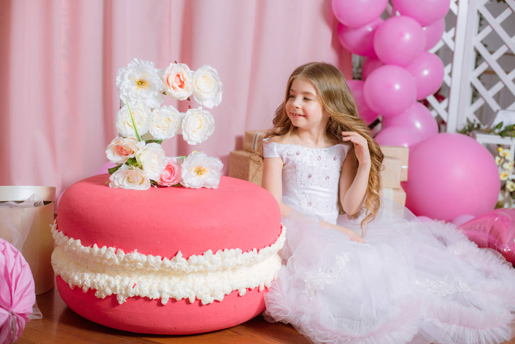Meisje met blonde lange haren vieren Happy Birthday Party met rose decor en ballonnen  - Foto, afbeelding