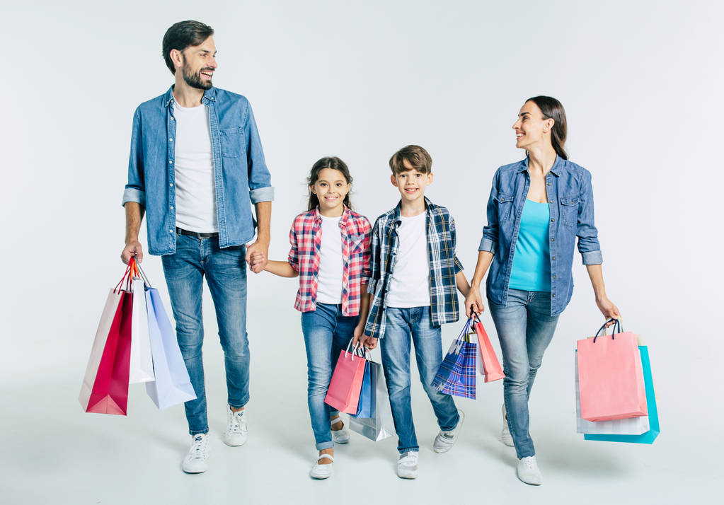 joven familia caucásica con bolsas de compras sobre fondo blanco, concepto de compras
  - Foto, Imagen