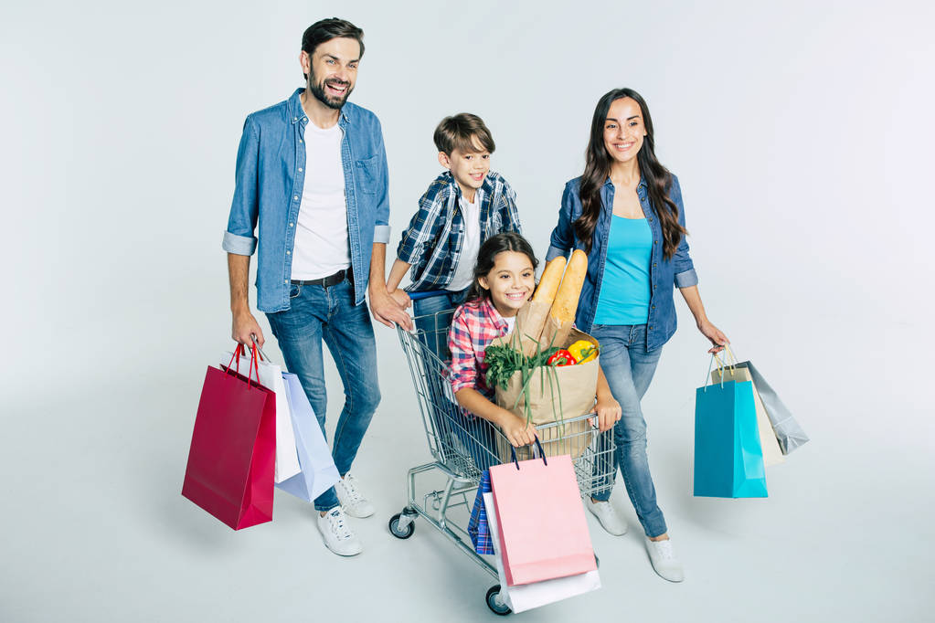 νεαρή Καυκάσιος οικογένεια με τσάντες αγορών σε άσπρο φόντο, ψώνια έννοια  - Φωτογραφία, εικόνα