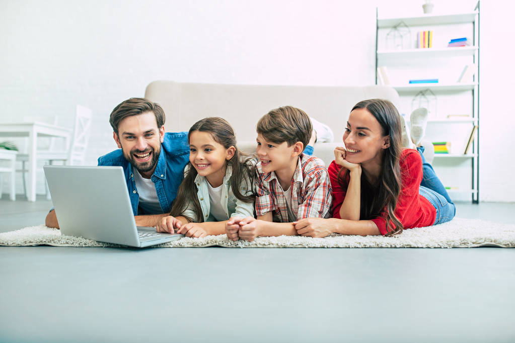 Família jovem usando laptop e passar o tempo em casa
 - Foto, Imagem