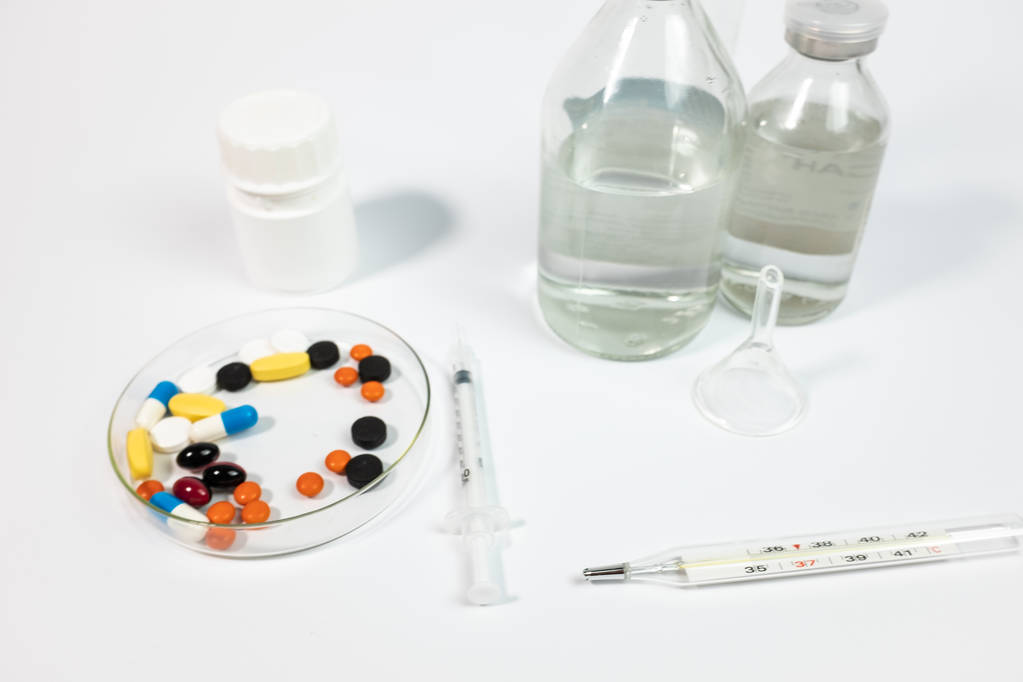 Різноманітні ліки та шприц, ізольовані на білому тлі
  - Фото, зображення