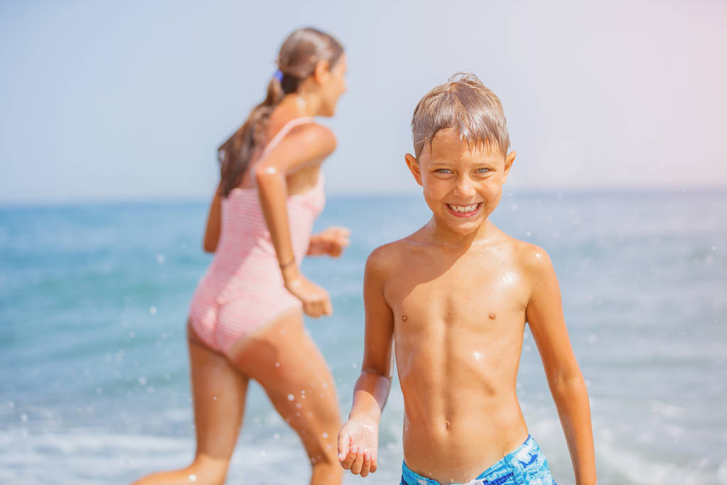 Duas crianças felizes se divertindo na praia
 - Foto, Imagem