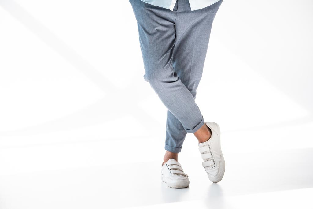 cropped shot of man in stylish pants and white shoes standing on white - Photo, Image