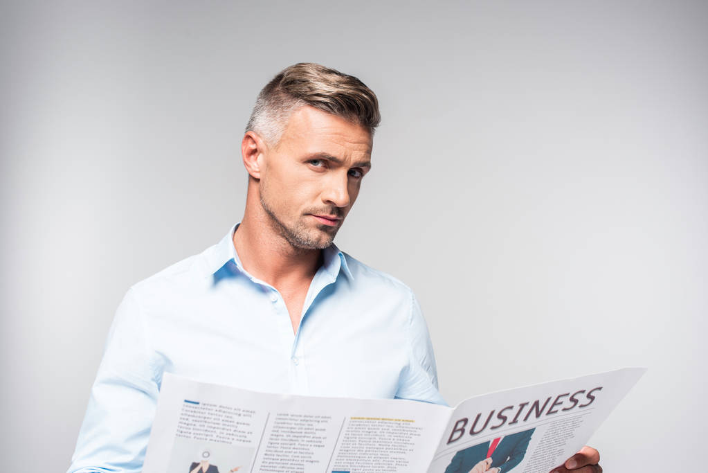 guapo adulto hombre de negocios con periódico de negocios mirando cámara aislada en blanco
 - Foto, Imagen