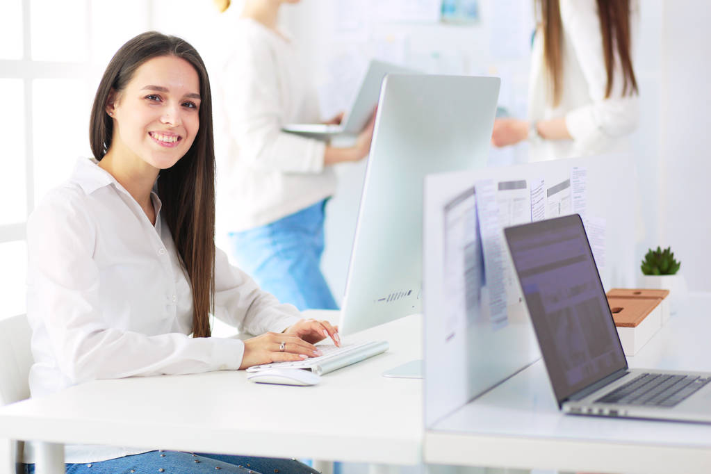 Aantrekkelijke zakenvrouw bezig met laptop op kantoor. Mensen uit het bedrijfsleven - Foto, afbeelding
