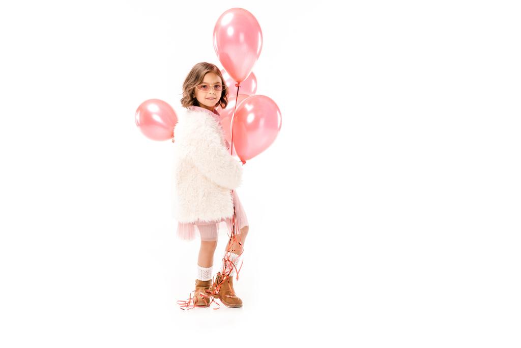 beautiful stylish child in fur coat with pink air balloons isolated on white - Photo, Image