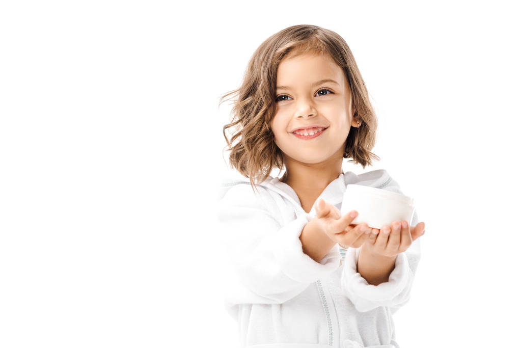 lindo niño en blanco albornoz mostrando crema corporal en manos aisladas en blanco
 - Foto, imagen