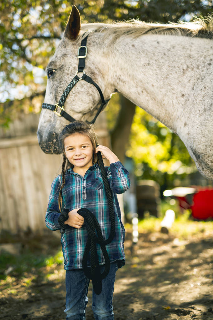 若い少女と馬の美しい秋の紅葉シーズン - 写真・画像