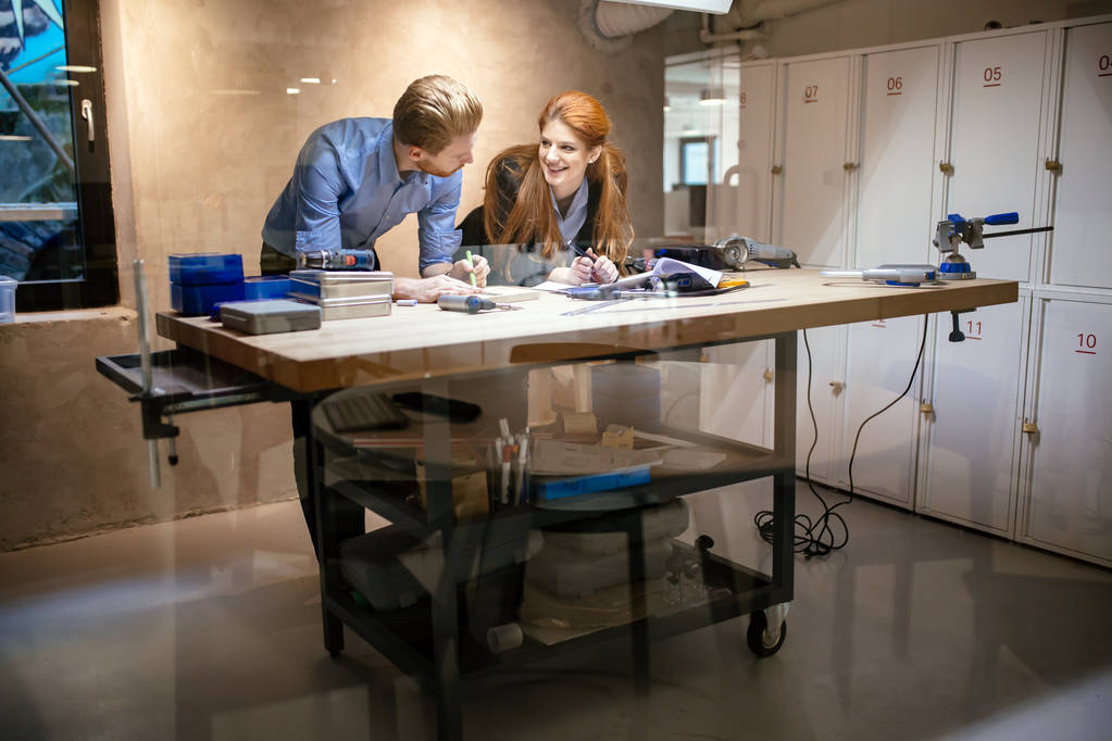 Mensen die werkzaam zijn in moderne mooie werkplaats met professionele apparatuur bij de hand - Foto, afbeelding
