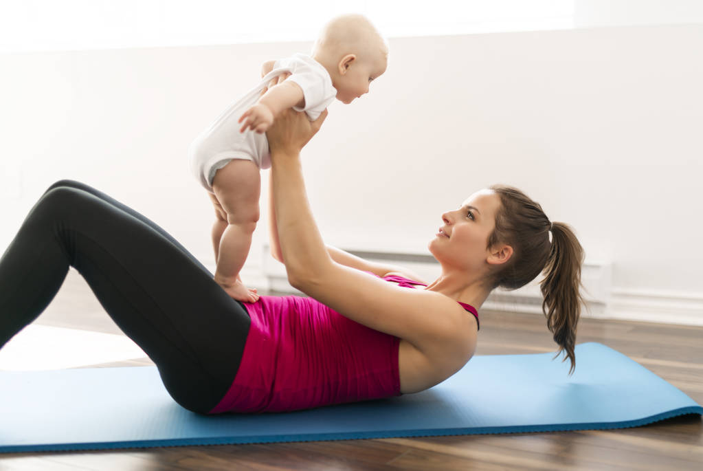 Un ritratto di bella giovane madre in abbigliamento sportivo con il suo piccolo bambino affascinante in sessione di allenamento
 - Foto, immagini