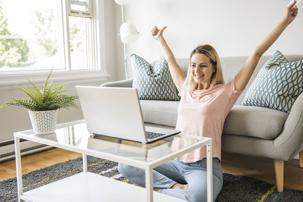Femme heureuse avec une carte de crédit et un ordinateur portable sur le canapé à la maison - Photo, image