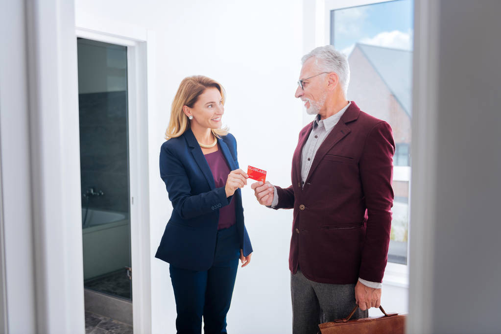 Agente imobiliário experiente levando cartão de seu cliente comprando novo apartamento de luxo
 - Foto, Imagem