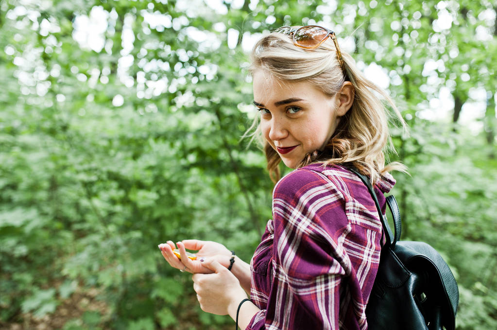 Retrato de una atractiva chica rubia posando con una brújula en un bosque
. - Foto, Imagen