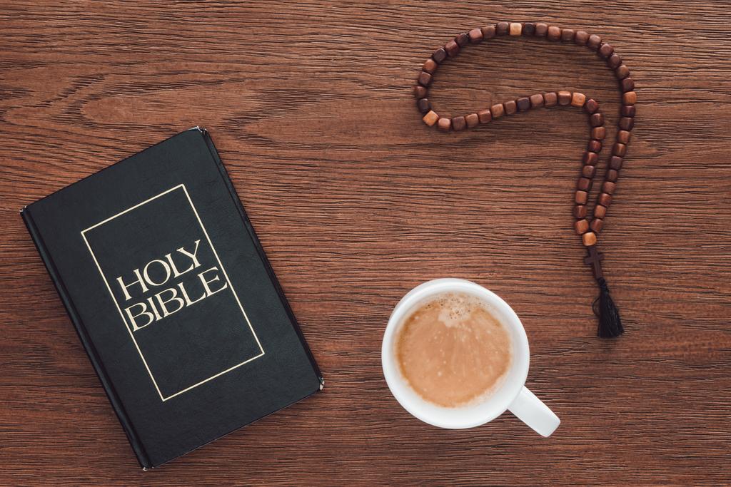 Ansicht der Heiligen Bibel mit Perlen und Kaffee auf Holztisch - Foto, Bild
