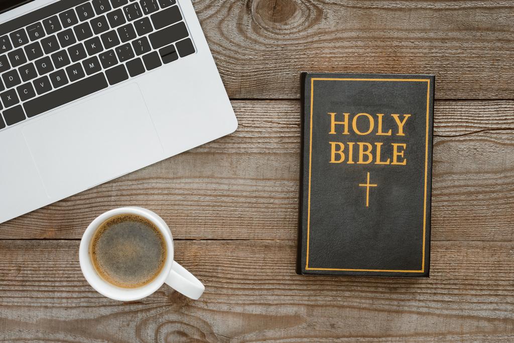верхний вид на святую Библию с ноутбуком и кофе на деревянном столе
 - Фото, изображение