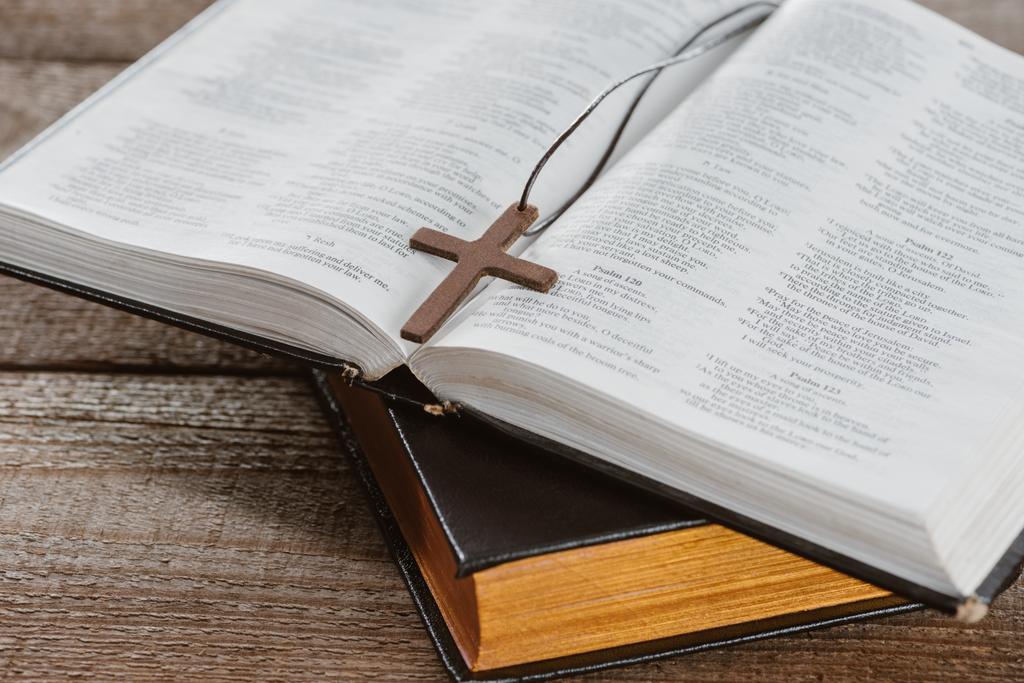 close-up shot of holy bibles with cross on wooden table - Photo, Image